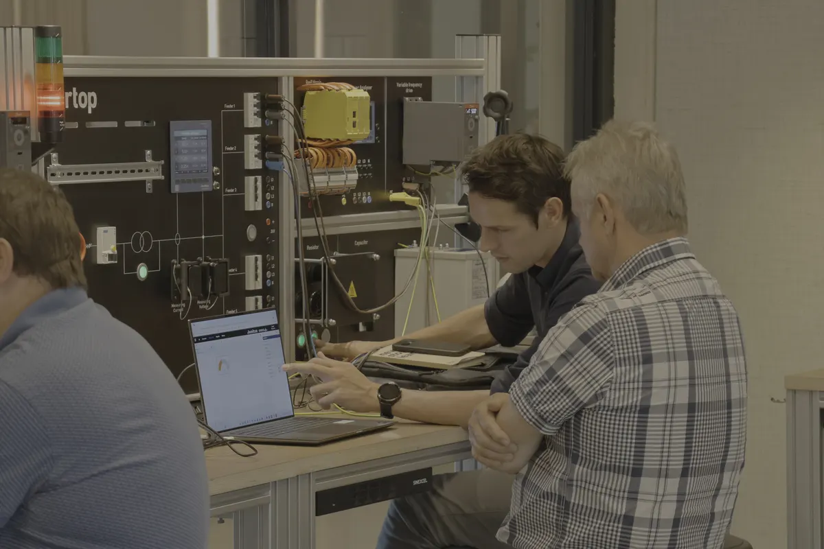 Meester naast gezel aan de testwand van fortop